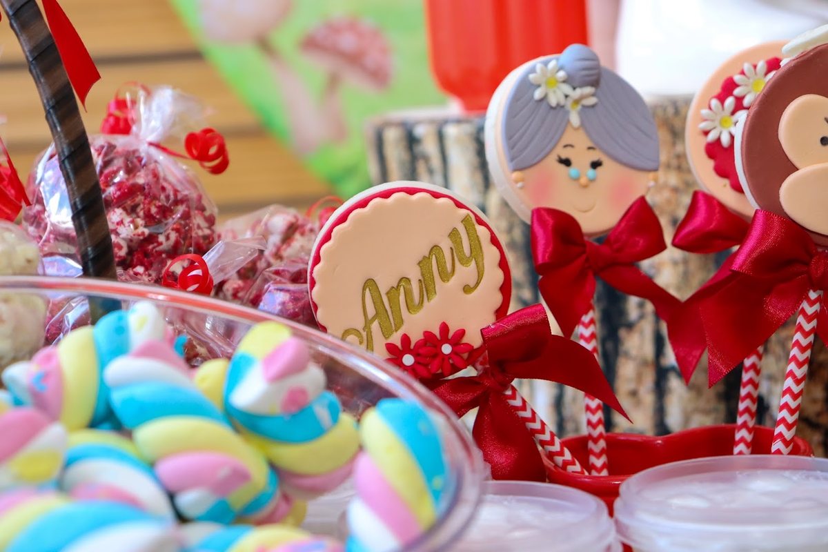Doces de festa: marshmallows coloridos e pirulitos decorados com laço vermelho